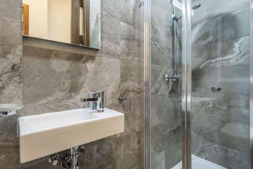 y baño con lavabo y ducha. en Nocturnal Elegance Apartment by Solea, en Sliema