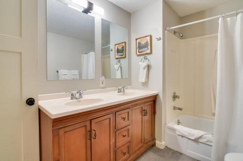 La salle de bains est pourvue d'un lavabo, d'une baignoire et d'un miroir. dans l'établissement Serene Kimberling City Retreat with Boat Dock and Slip, à Kimberling City