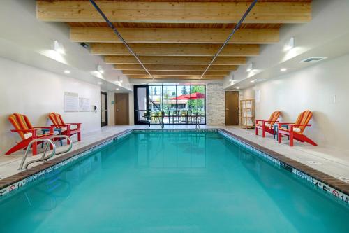 a swimming pool with red chairs and a swimming pool at Home2 Suites By Hilton Marysville in Marysville