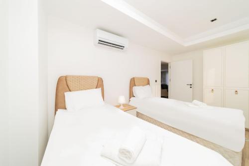 twee bedden in een kamer met witte muren bij Flat in Antalya