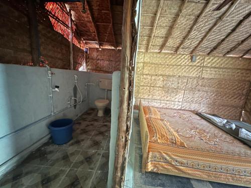 a small room with a bed and a toilet at The Gravity Cafe -A Unit Of StayChillHampi in New Hampi