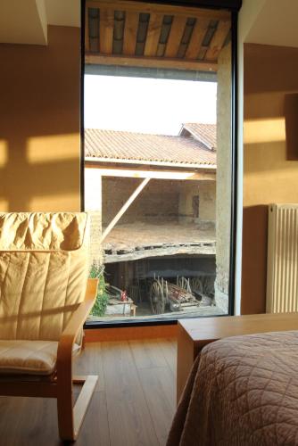 a bedroom with a view of a building through a window at La ferme de Berlioz in La Côte-Saint-André