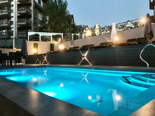 a swimming pool at night with lights at Private Spa Luxury apartments in Bansko