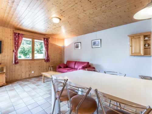 un salon avec un canapé rouge et une table dans l'établissement Rez-de-chalet avec terrasse plein Sud, sur les pistes de ski de fond – 6 pers, La Clusaz - FR-1-437-29, à La Clusaz