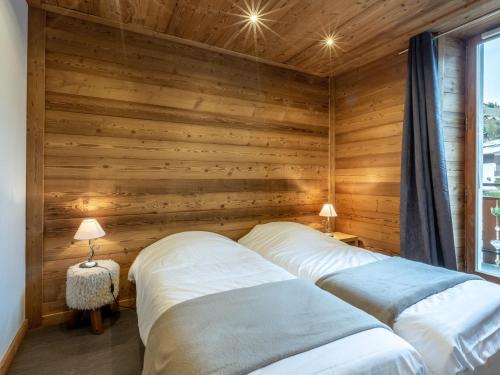 deux lits dans une chambre aux murs en bois dans l'établissement Appartement 3 chambres au centre, proche des remontées mécaniques, avec parking et Wi-Fi - FR-1-437-3, à La Clusaz