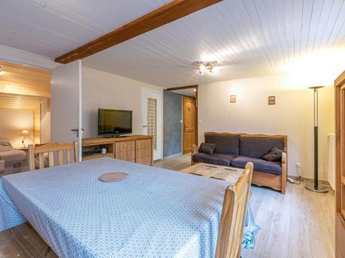 een slaapkamer met een blauw bed en een bank bij Appartement La Clusaz, 3 pièces, 6 personnes - FR-1-437-37 in La Clusaz