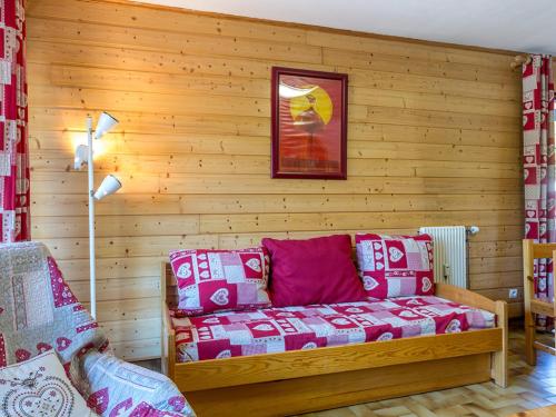 - un salon avec un canapé mural en bois dans l'établissement Appartement cosy, proche pistes et centre, 3 pièces, 6 pers, cheminée, balcon, parking - FR-1-437-53, à La Clusaz