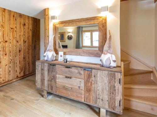 La salle de bains est pourvue d'une commode en bois avec un miroir. dans l'établissement Chalet Chaleureux - 1 Ch - 4 Pers - Terrasse - Parking - FR-1-437-75, à La Clusaz