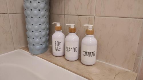 a group of four bottles sitting on a counter in a bathroom at Apartment with pool and gardens near the coast in San Miguel de Abona