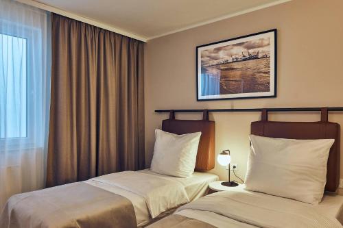 a hotel room with two beds and a window at Makro Apartments in Hamburg