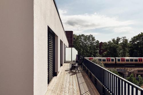 a building with a balcony with a train on the tracks at Makro Apartments in Hamburg