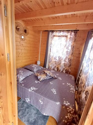 sypialnia w drewnianym domku z łóżkiem w obiekcie Chalet d'une chambre avec terrasse amenagee et wifi a L'Etang Sale w mieście Étang-Salé