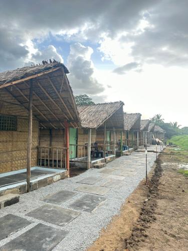 a row of buildings with roofs on a field at The Gravity Cafe -A Unit Of StayChillHampi in New Hampi