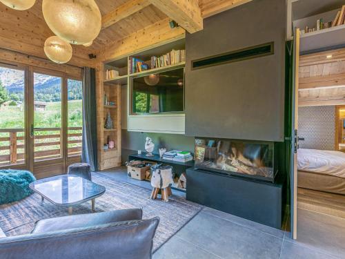 un salon avec une cheminée et un lit dans l'établissement Chalet 4**** La Clusaz: sur les pistes, 10 pers, terrasse, garage, Wifi, linge inclus - FR-1-437-80, à La Clusaz