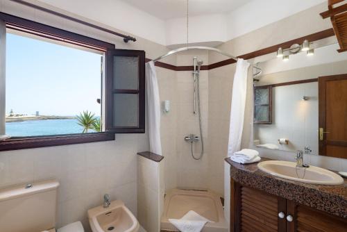 a bathroom with a sink and a toilet and a window at Casa Maesa in Playa Honda