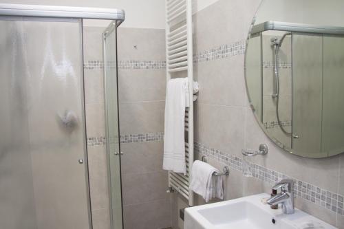 a bathroom with a shower and a sink and a mirror at Hotel Ca' Serena in Sirmione