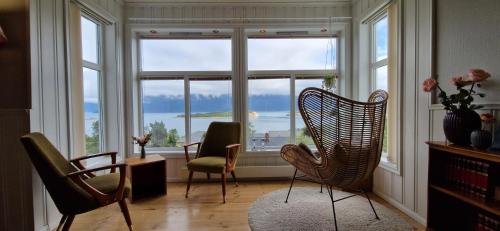 Habitación con 3 sillas y ventana grande. en Main floor in the Lyngen Alps, whole house rentable, en Lyngseidet
