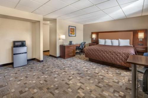 um quarto de hotel com uma cama e uma secretária em El Rancho Hotel em Williston