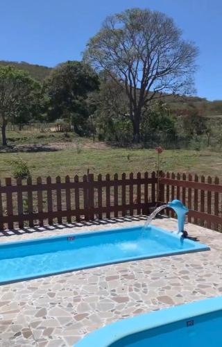 a swimming pool with a water fountain at Chalé Topázio no Recanto Diamantina entre Palmeiras e Capão in Palmeiras