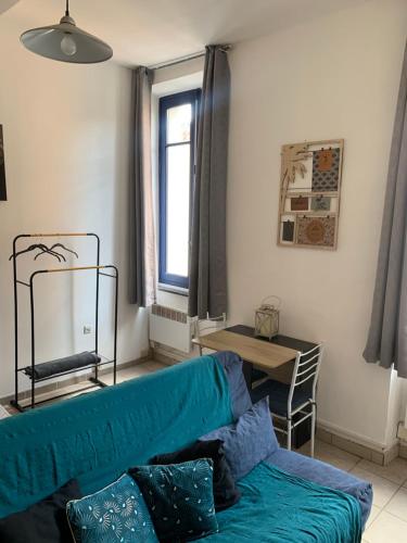 - un salon avec un canapé bleu et une fenêtre dans l'établissement Studio en plein centre, à Carcassonne