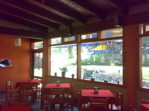 un restaurant avec des tables rouges, des chaises et des fenêtres dans l'établissement Hotel Casa Valle, à Valle de Bravo