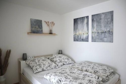 um quarto com uma cama com almofadas e duas fotografias em Ferienwohnung Piendl em Münsingen