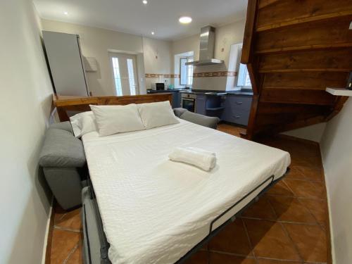 uma cama grande num pequeno quarto com uma cozinha em Villa Maribel em Foz