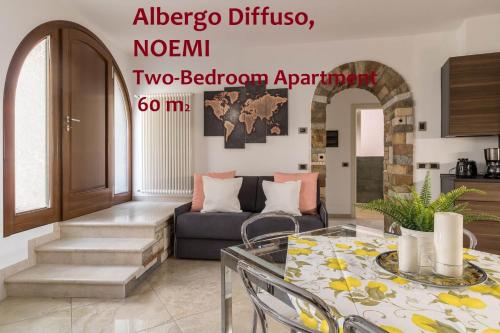 ein Wohnzimmer mit einem Sofa und einem Tisch in der Unterkunft Albergo Diffuso Borgo Piovere in Tignale in Tignale