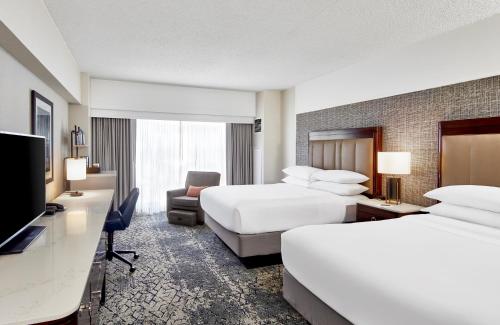 um quarto de hotel com duas camas e uma televisão de ecrã plano em Sheraton Indianapolis Hotel at Keystone Crossing em Indianápolis