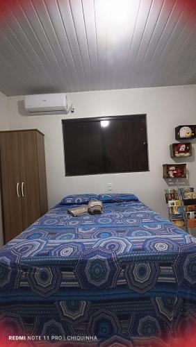 um quarto com uma cama e uma televisão na parede em Studio Aconchegante em Palmas