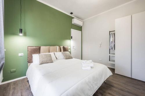 - une chambre avec un grand lit blanc et un mur vert dans l'établissement Cucchiarti Suite 3A, à Modène