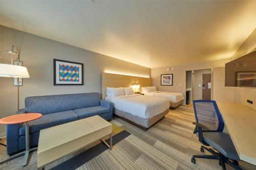 ハーミストンにあるHoliday Inn Express & Suites - Hermiston Downtown, an IHG Hotelのベッドとソファ付きのホテルルーム
