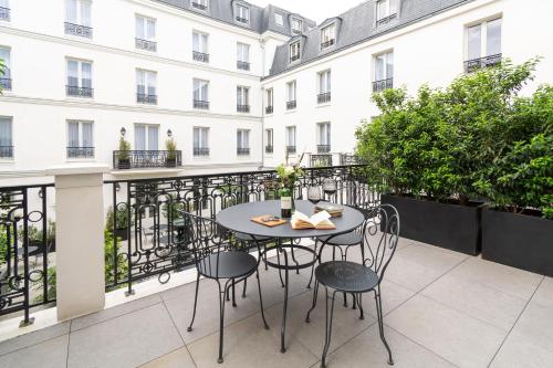 a patio with a table and chairs on a balcony at Hôtel & SPA Napoléon in Fontainebleau
