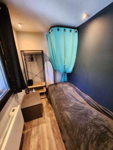 - une chambre avec un lit et un rideau bleu dans l'établissement Les nids chalet 4.5, à La Lechere