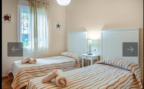 1 dormitorio con 2 camas con animales de peluche en Islantilla golf playa, en Huelva