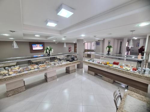 um corredor de padaria com muita comida em exposição em San Marino Palace Hotel em Guarapuava
