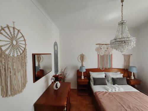 um quarto com uma cama e um lustre em Casa da Tina na Nazaré