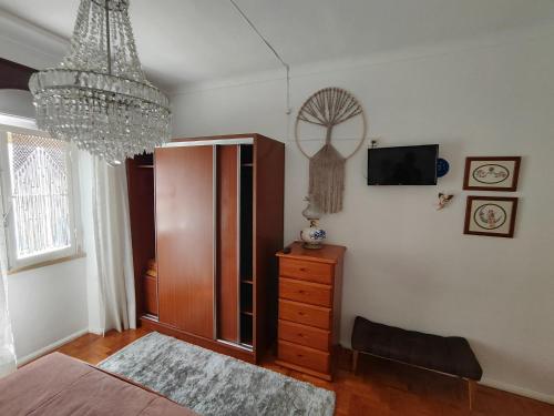 a bedroom with a bed and a chandelier at Casa da Tina Conforto Familiar no Sítio da Nazaré in Nazaré