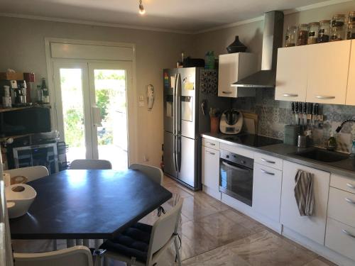 une cuisine avec une table et un réfrigérateur dans l'établissement Maison 3 chambres au calme avec piscine, à La Fare-les-Oliviers