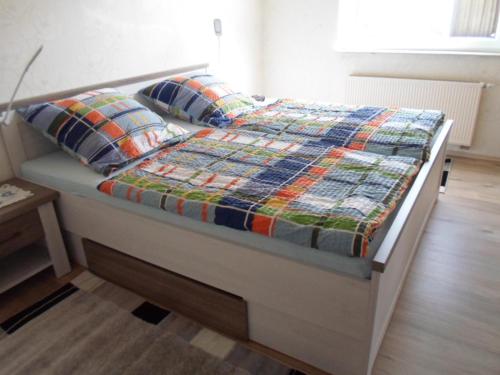 a bed with a quilt and two pillows on it at Am Reichelbach schöne Natur kostenlose Stellplätze in Neuwied