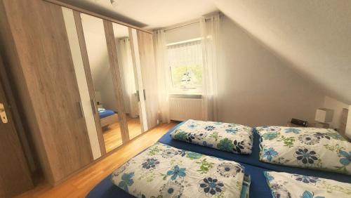 ein kleines Schlafzimmer mit 2 Betten und einem Fenster in der Unterkunft Ferienwohnung am See, Hage / Norddeich in Hage