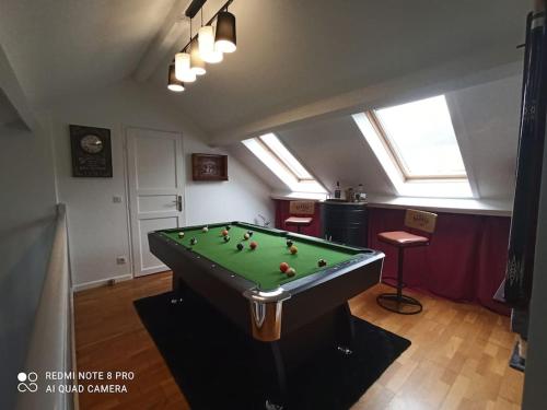 a room with a pool table in a room at Charmante maison avec piscine chauffée, salle de cinéma et bar in Auffargis