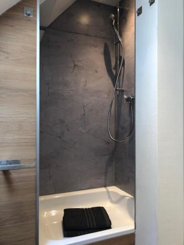 y baño con ducha y toalla negra. en 2 Zimmer Wohnung in Giessen-Mitte en Gießen