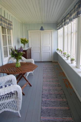 a porch with a table and chairs and windows at Bjärkas Golf & Country Club in Nivelax
