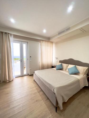 a bedroom with a large bed with blue pillows at Le Gorgoni Tropea b&b in Tropea