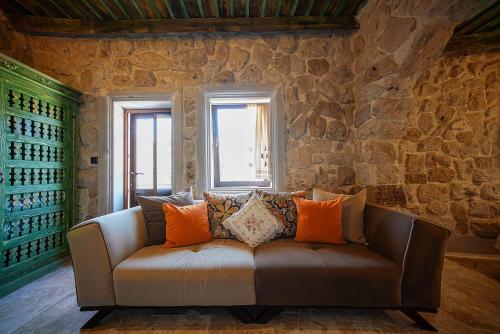 a couch in a room with a stone wall at Aysel Inn House in Goreme