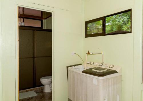 ein weißes Bad mit einem WC und einem Waschbecken in der Unterkunft Casita Colorada, Sierpe de Osa in Sierpe