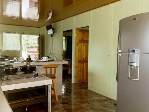 a kitchen with a stainless steel refrigerator in it at Casita Colorada, Sierpe de Osa in Sierpe
