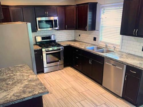 a kitchen with wooden cabinets and stainless steel appliances at Cute house in quiet neighborhood in Saginaw