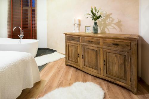 a bathroom with a wooden dresser and a bath tub at STING Boutique Apartments in Ostrava